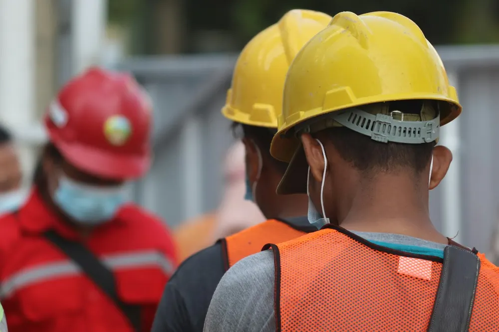 Deux salariés casqués et masqués dans un environnement de travail