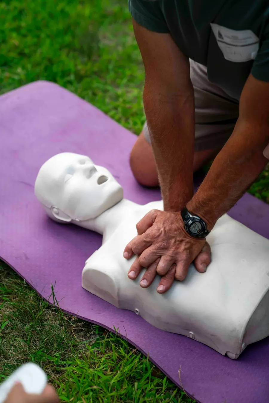 Mains d’un formateur pratiquant un massage cardiaque sur un mannequin de secourisme